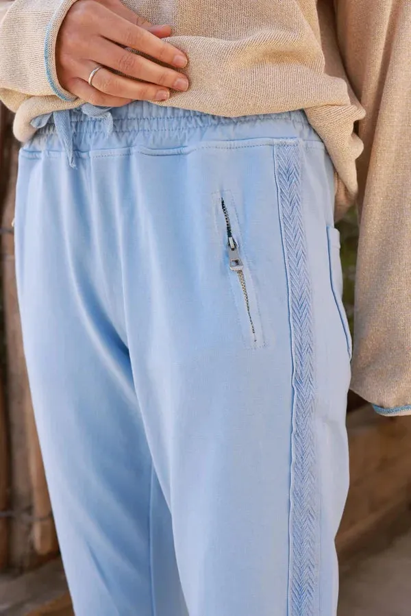 Light blue cotton jogging bottoms with embroidered cheveron outseams
