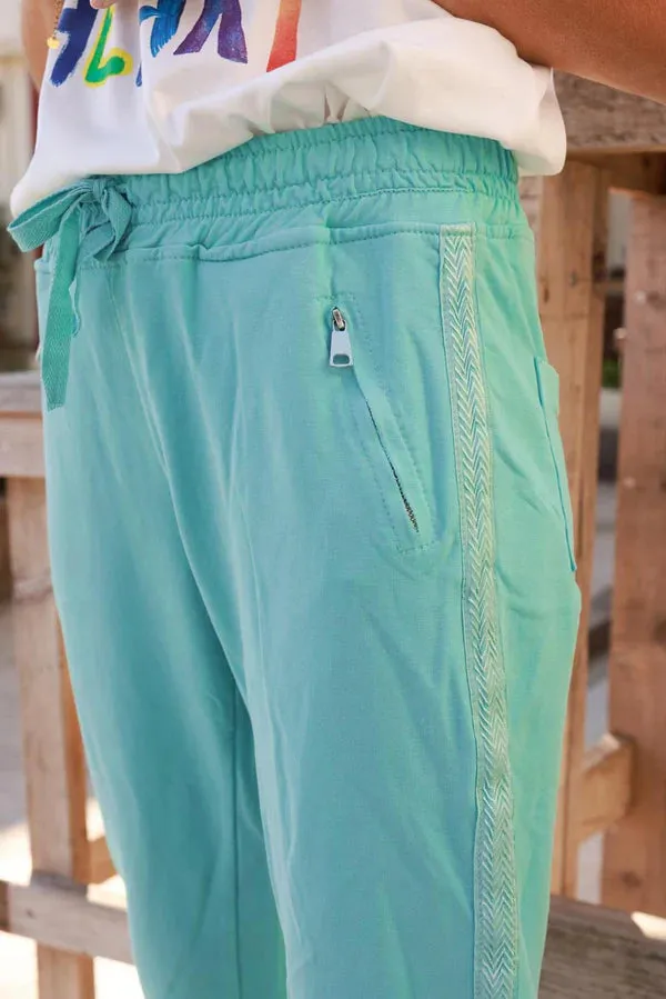 Turquoise cotton jogging bottoms with embroidered cheveron outseams